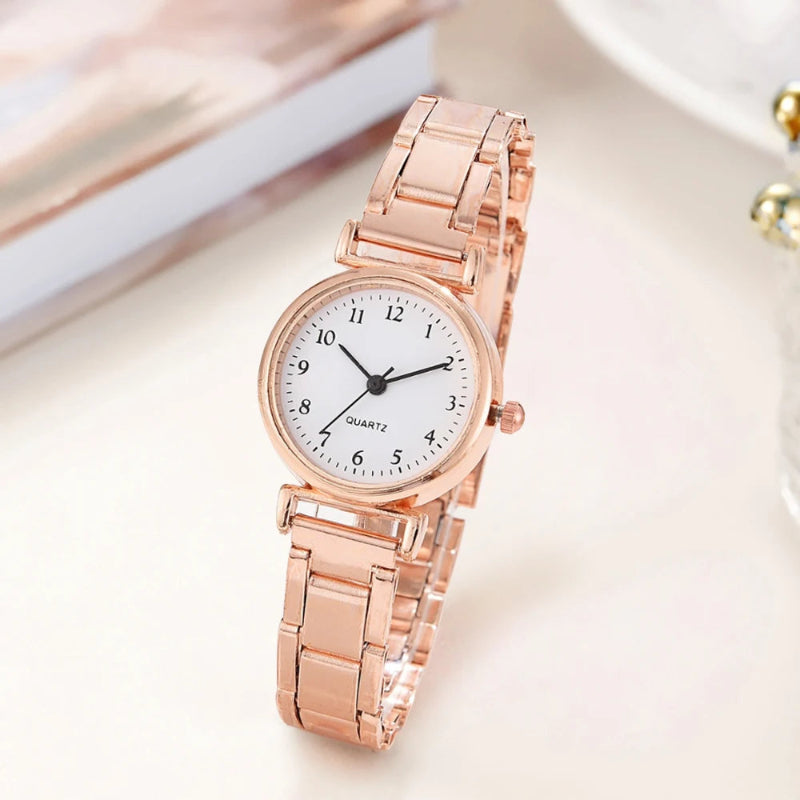 Rose gold watch with a white face on a light background