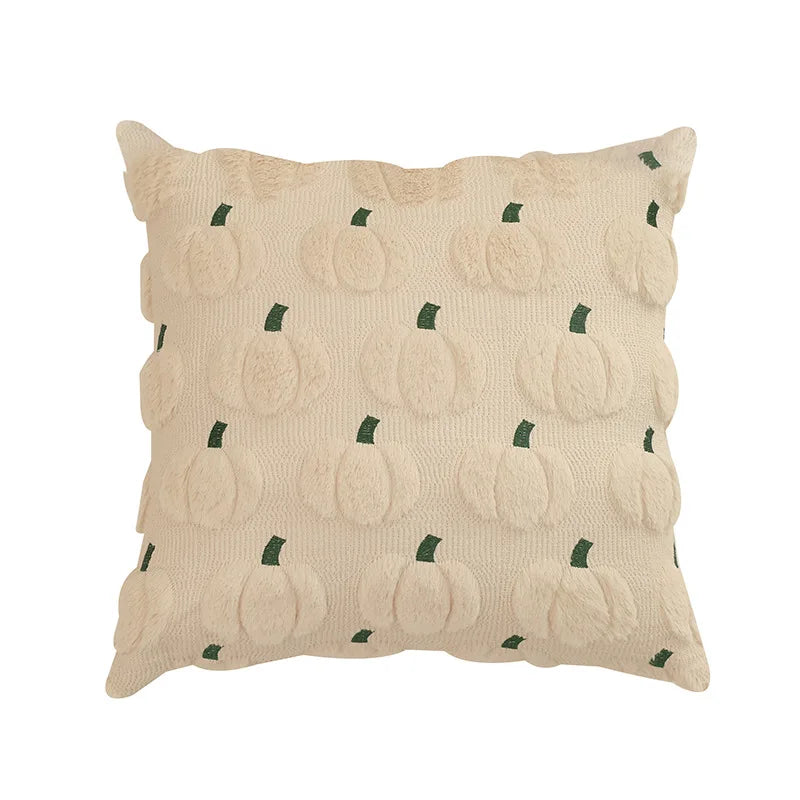 A square throw pillow in cream beige textured fabric with a raised pumpkin pattern and small dark green stems, shown on a plain white background.