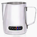 Stainless steel milk pitcher with temperature gauge on a white background