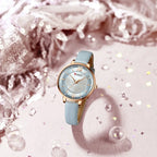 Watch with light blue strap and gold casing on a decorative background