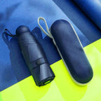 Blue umbrella and its case on a blue and yellow background