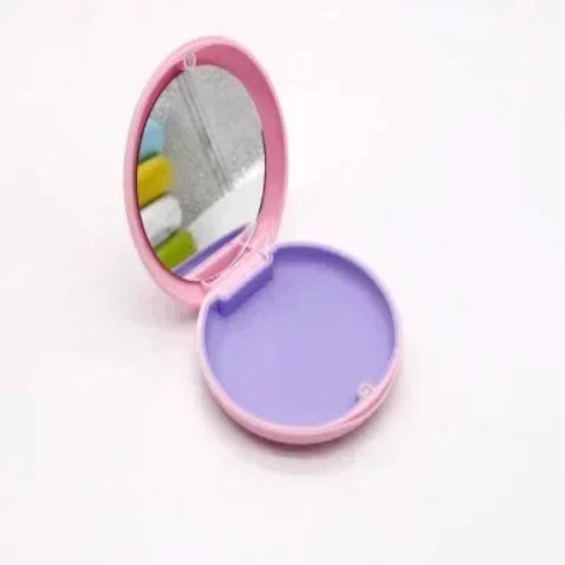 Compact mirror with pink frame and purple interior on a white background