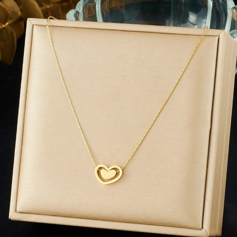 Gold heart-shaped necklace on a beige jewelry box