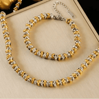 Gold and silver beaded necklace and bracelet set on a beige surface with 'EILIECK' branding.