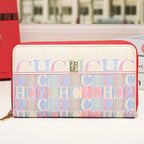 A Gucci zip-around wallet with a cream canvas upper section and a colorful monogram patterned lower section, featuring red trim and a gold-tone CC logo on the front.