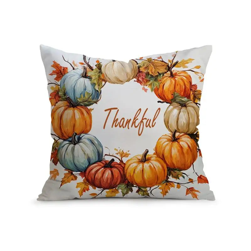 A square throw pillow featuring a watercolor autumn wreath design with pumpkins, fall leaves, and the word 'Thankful' in brown script on a white background.