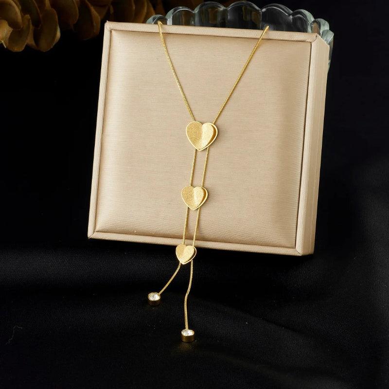 Gold heart-shaped necklace on a beige card with a dark background
