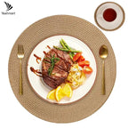 Steak with vegetables on a white plate with a gold fork and spoon, on a woven placemat.
