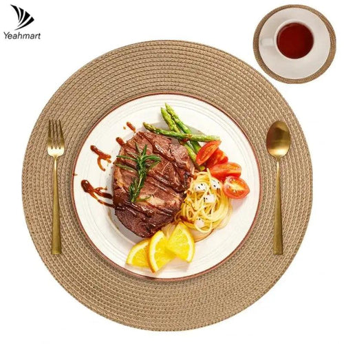 Steak with vegetables on a white plate with a gold fork and spoon, on a woven placemat.