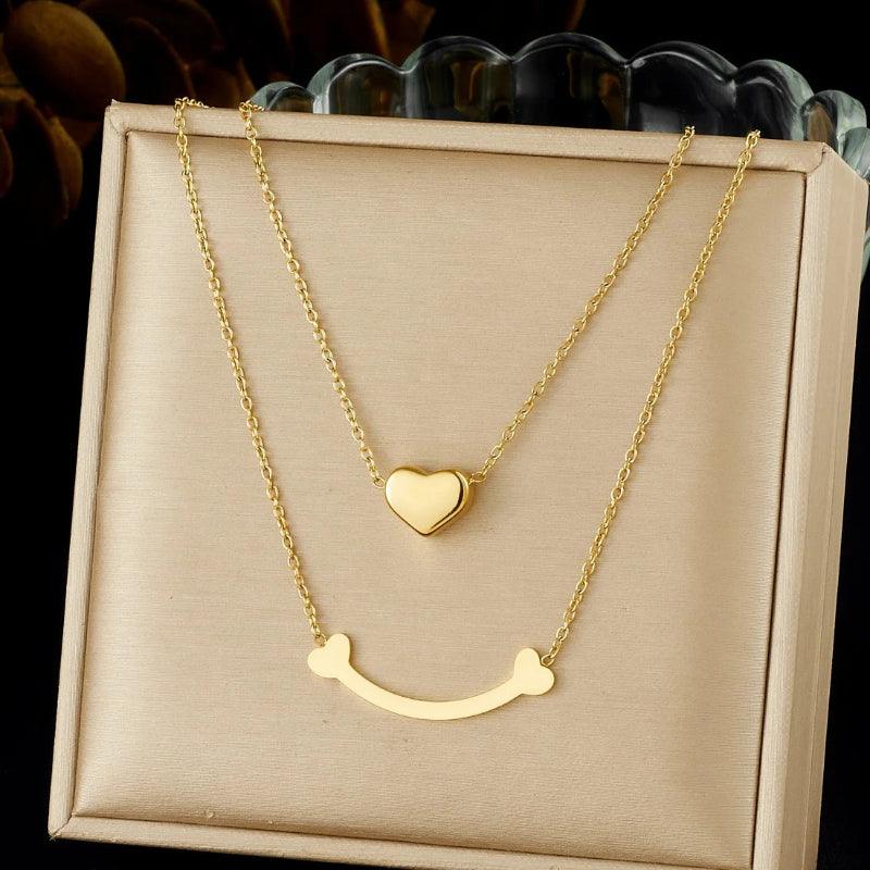 Gold necklace with heart pendant on a beige display box