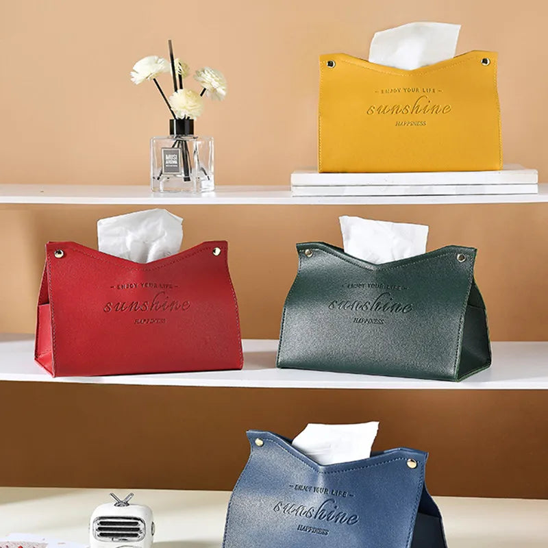 Four colorful tissue holders with 'sunshine' text on a shelf against a beige wall.