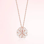 Rose gold four-leaf clover pendant necklace on a light pink background