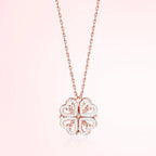 Rose gold four-leaf clover pendant necklace on a light pink background