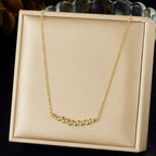 Gold necklace on a beige display box with a dark background