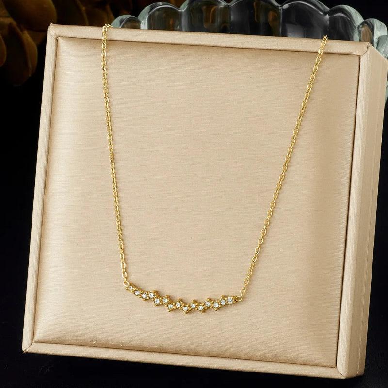 Gold necklace on a beige display box with a dark background