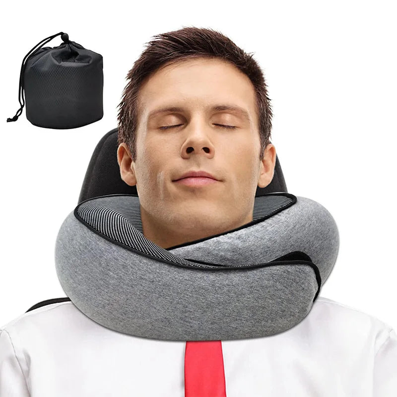 A man wearing a gray neck pillow with black trim, shown against a white background with a small black drawstring storage pouch in the upper left corner.