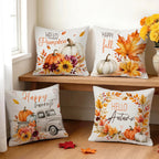 Four decorative throw pillows with autumn-themed prints are arranged on a wooden bench and floor in a bright room. The pillows feature fall illustrations including pumpkins, leaves, flowers, and phrases such as 'Hello Pumpkin,' 'Happy fall,' 'Happy harvest,' and 'Hello Autumn.