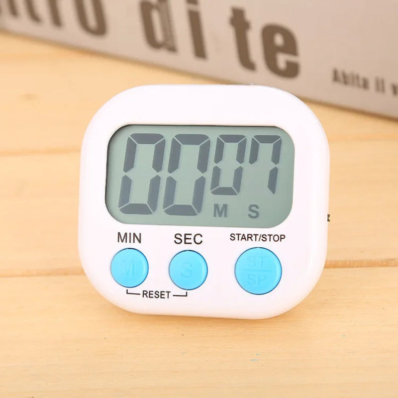 A white digital kitchen timer with a gray LCD display showing 00:07, featuring three light blue buttons labeled MIN, SEC, and START/STOP, placed on a light wood surface.