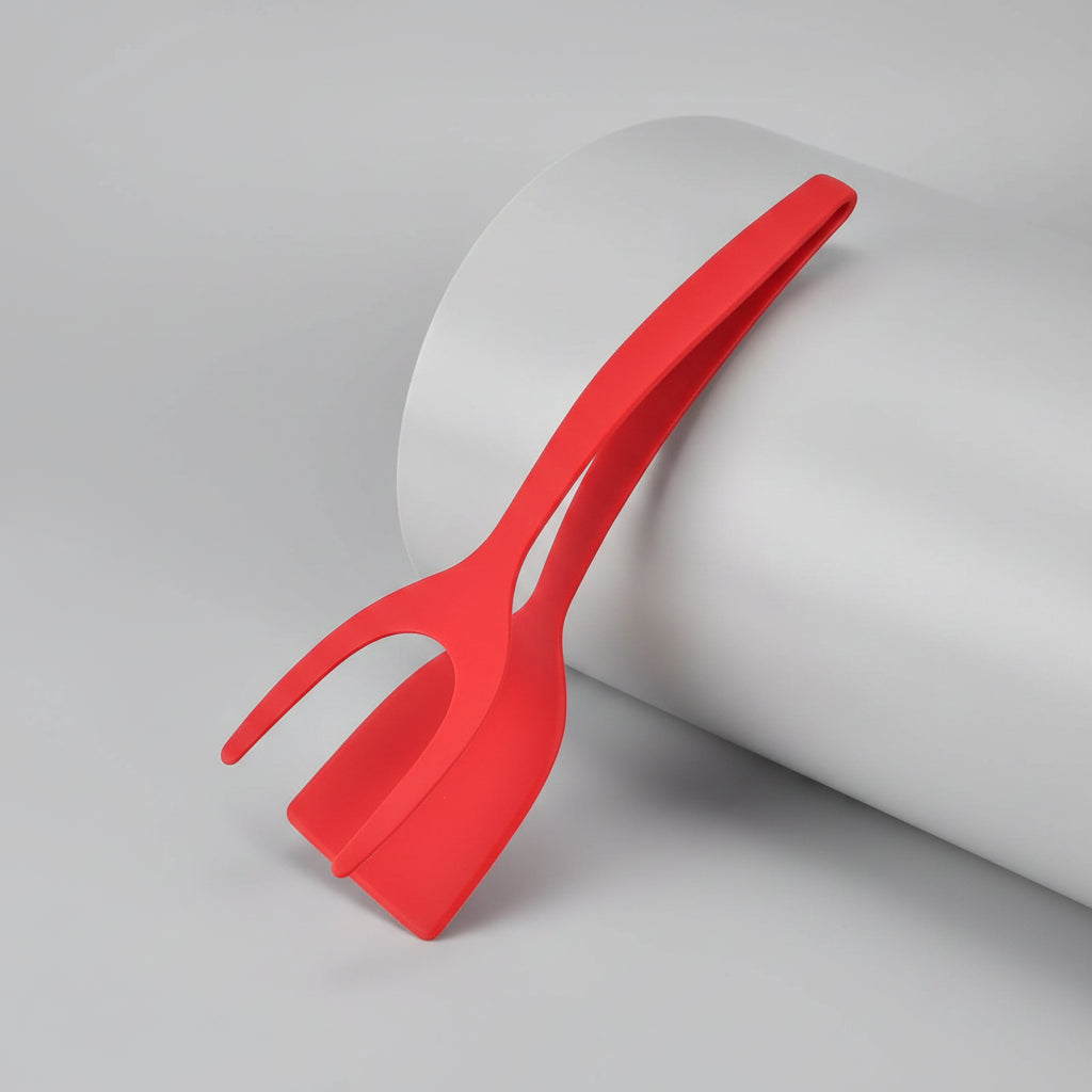 Red plastic tool with a long handle and wide head on a white background