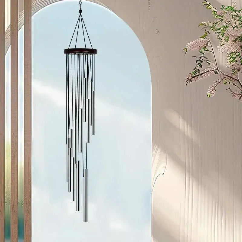 Wind chime hanging against a light blue sky with a blurred background