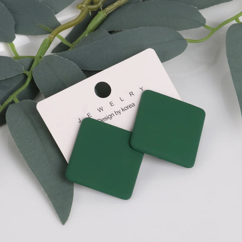 Green square earrings on a white card with 'Jewelry by Korea' branding, surrounded by green leaves.
