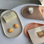 Trays with cookies, a bar of butter, and a candle on a light surface