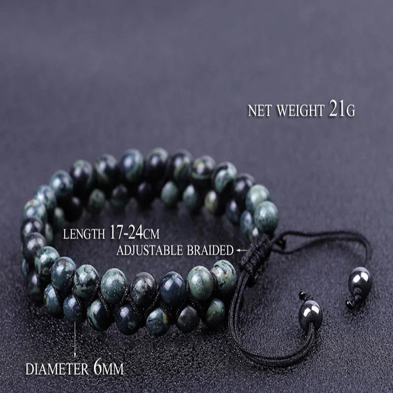 A beaded adjustable braided bracelet made of dark green and black Kambaba jasper beads, displayed on a dark textured background with text overlays showing its dimensions, weight, and style number.