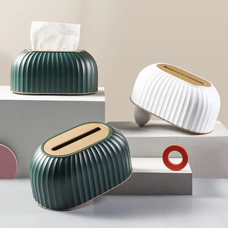Three modern tissue holders in green, white, and beige on a neutral background