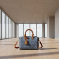 Blue handbag with brown handles and strap on a white background