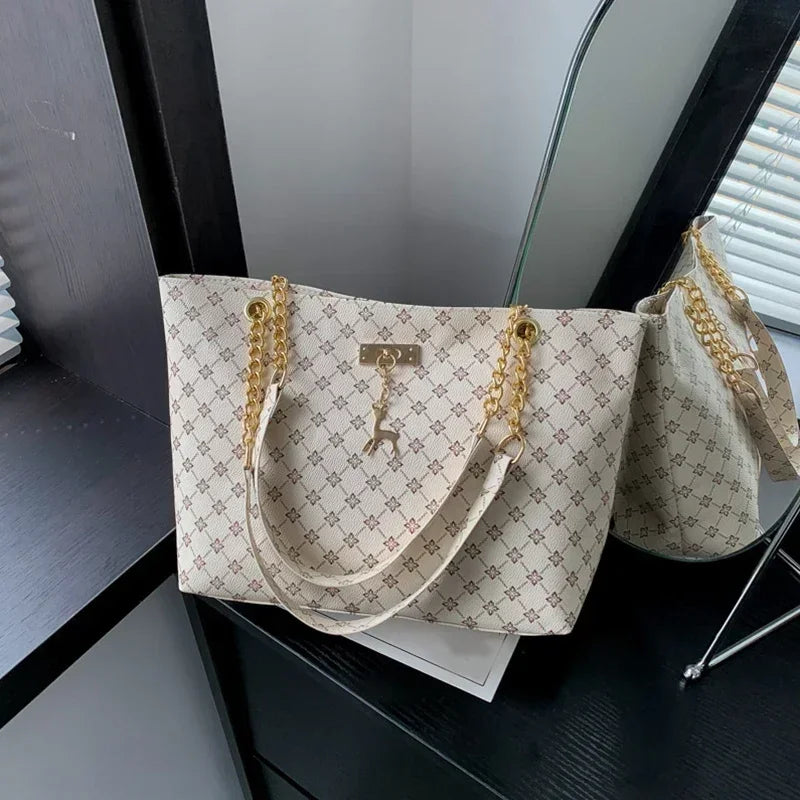 Beige handbag with gold chain details on a dark surface