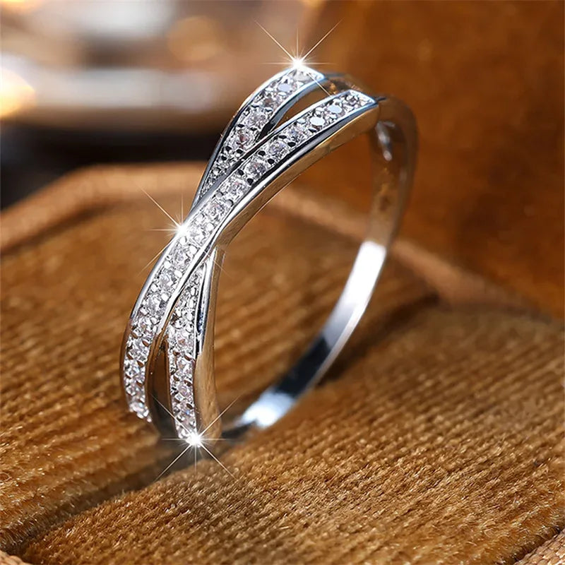 Silver ring with diamond accents on a wooden surface