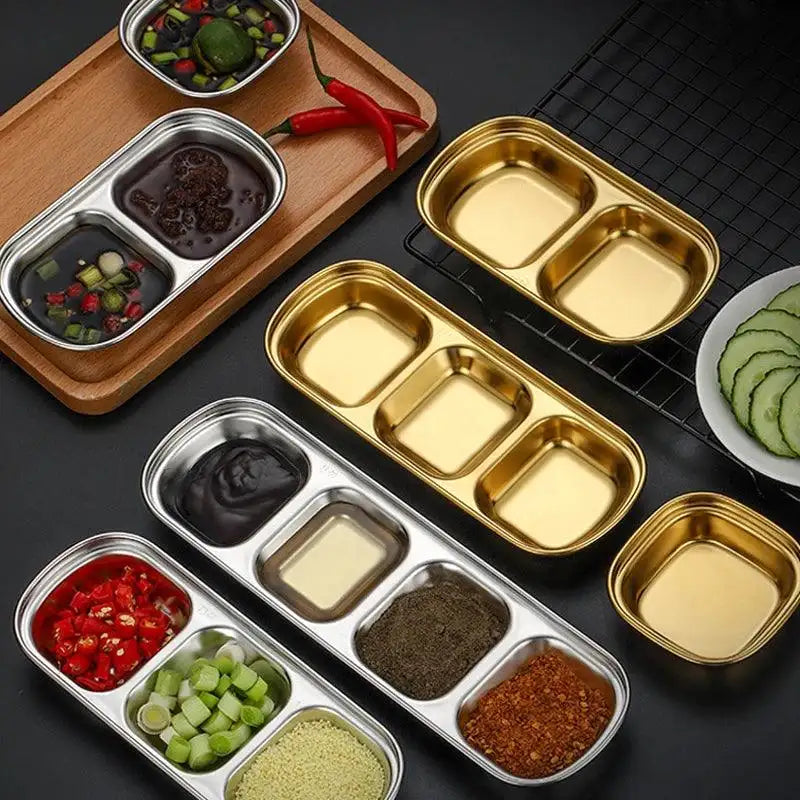 Metallic food containers with compartments filled with various ingredients on a dark surface.