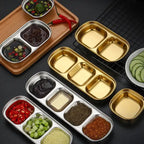 Metallic food containers with compartments filled with various ingredients on a dark surface.