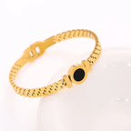 Gold bracelet with a black stone on a white background