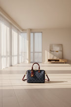 Blue handbag with red accents and a visible brand logo on a white background