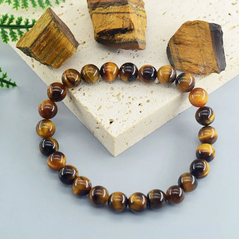 Tiger eye beaded bracelet on a light stone surface with tiger eye stones.