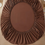 Brown fitted sheet on a bed with 'vave' branding.