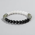 Beaded bracelet with black, white, and green stones on a wooden surface with 'Self-Love' text.
