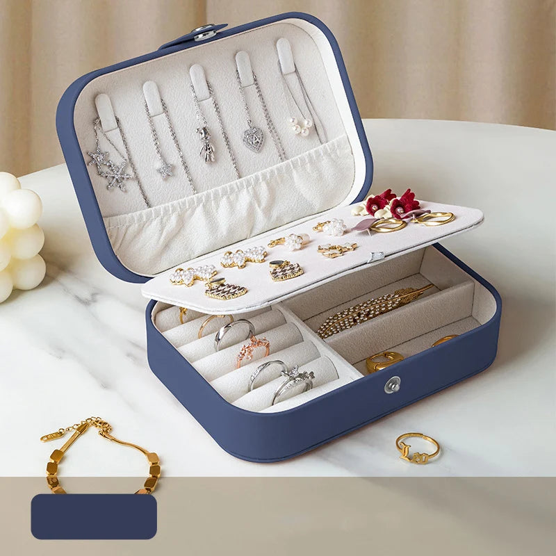 Open jewelry case with various jewelry items on a marble surface
