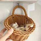 Wicker basket with garlic and mushrooms hanging on a hook.
