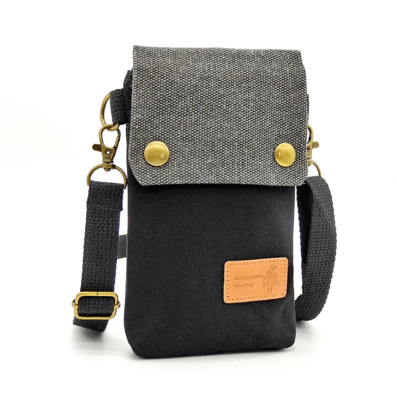 Small crossbody bag with gray top section and black bottom section on a white background