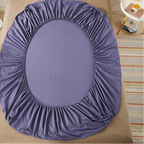 Purple fitted sheet on a bed with 'vave' branding.