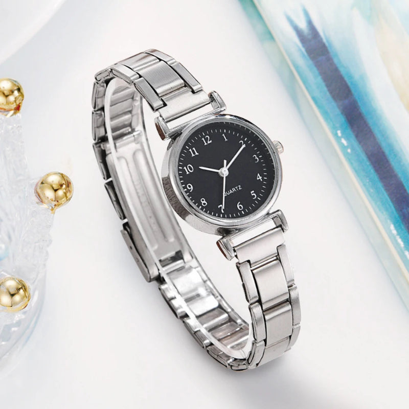 Silver watch with a black dial on a light background