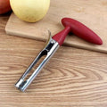 Apple peeler with red handle on a wooden surface
