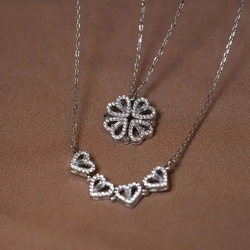 Silver necklace with heart-shaped pendants on a brown background