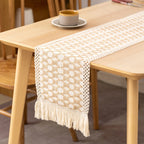 Beige and white patterned table runner on a wooden table with a blurred background
