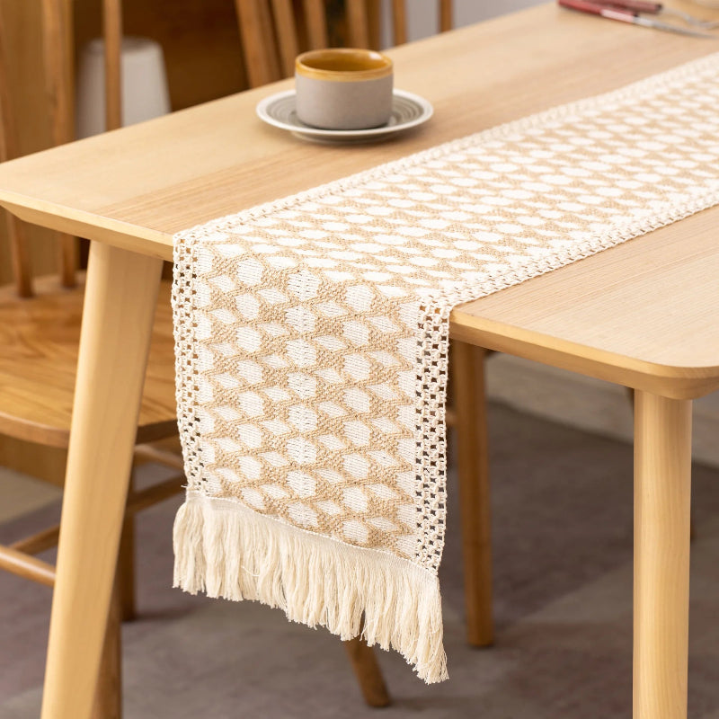Beige and white patterned table runner on a wooden table with a blurred background