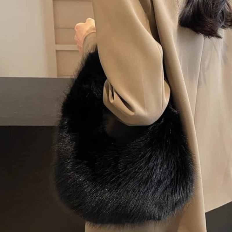 Person holding a black fur bag indoors
