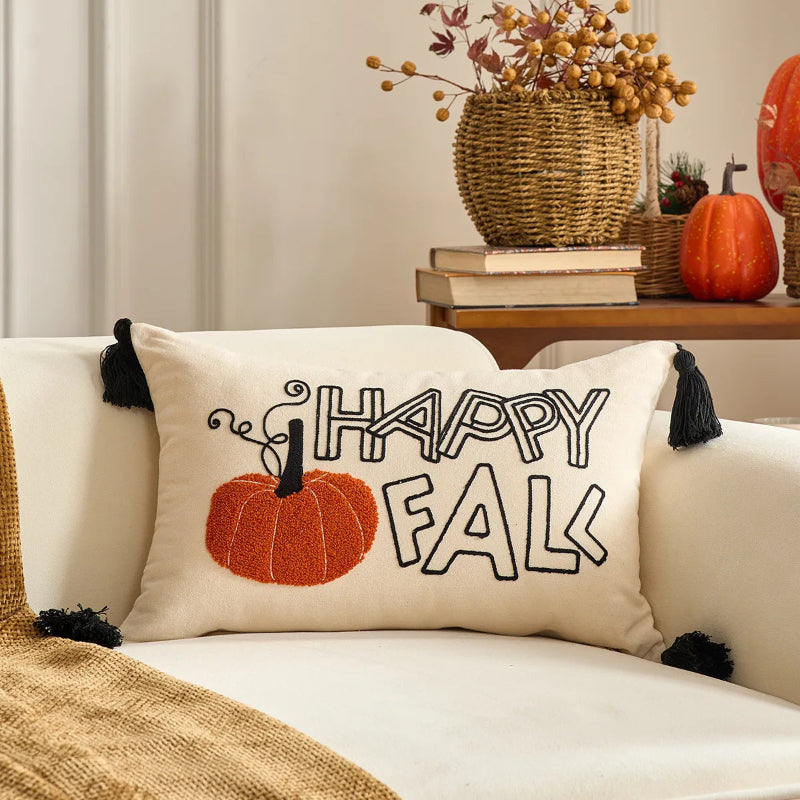 Decorative pillow with 'Happy Fall' text and pumpkin graphic on a couch.