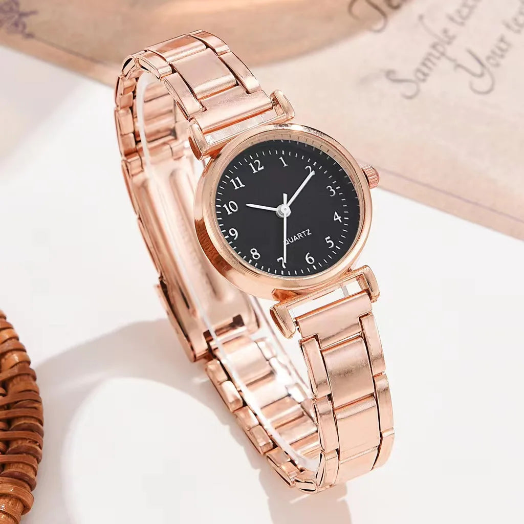 Rose gold watch with black dial on a white background